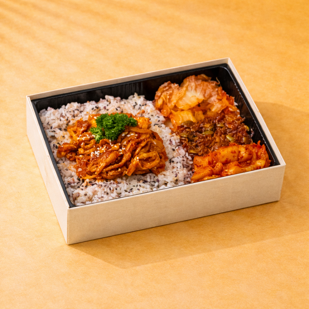Spicy gochujang marinated chicken, served with rice and classic banchan in a bento box
