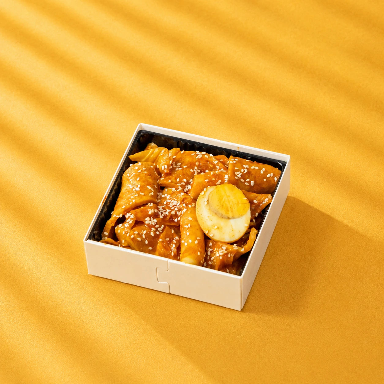 Chewy Korean rice cakes bathed in a rich sweet-spicy sauce, paired with savoury fish cake and hearty egg