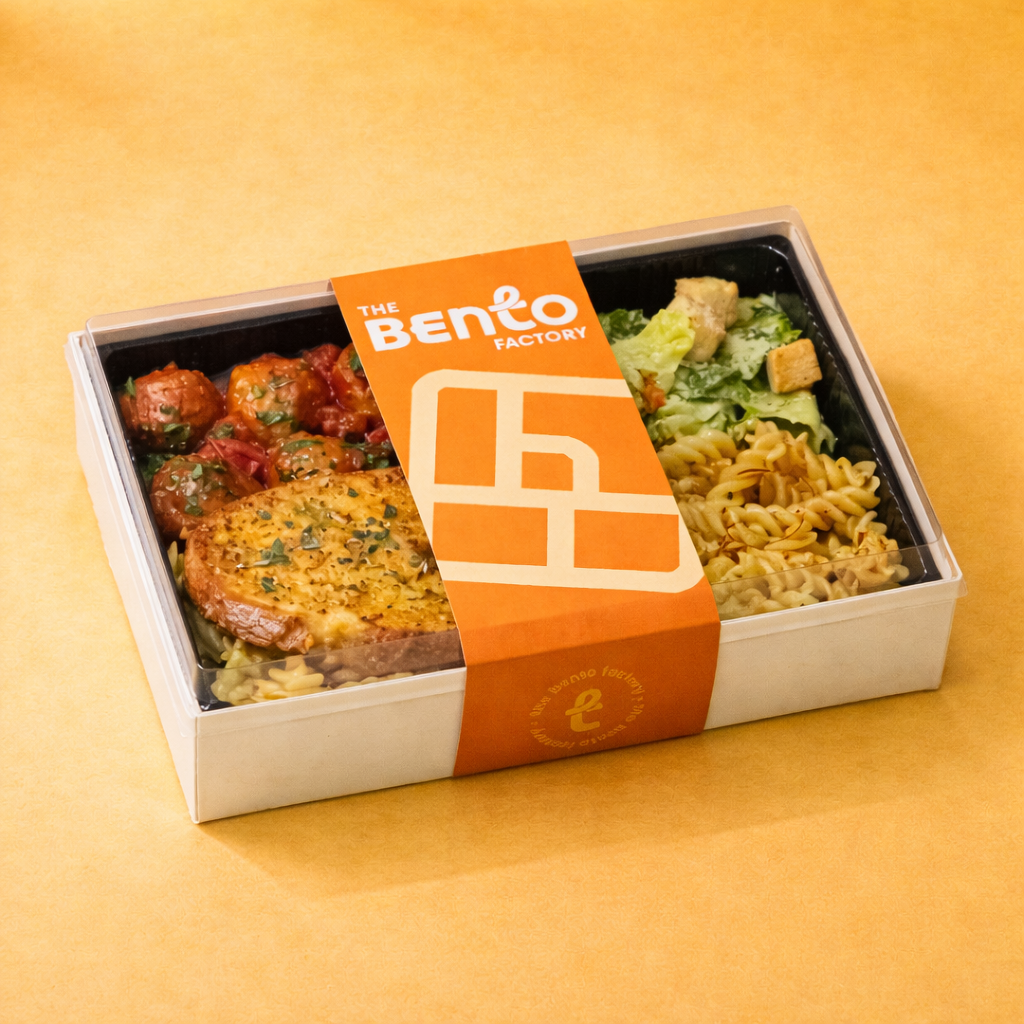 Rustic meatball with pasta and salad in a crate bento box and the bento factory brand sleeve
